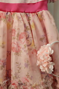 Floral dress with a pink ribbon and a floral headband on a light background